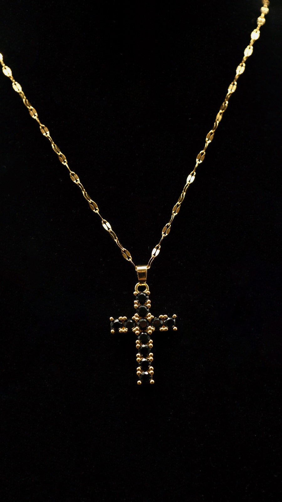 Goldene Kreuzkette mit schwarzen Steinen